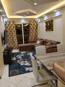 a living room with a couch and a table and chairs at White Pearl Apartment in Alexandria