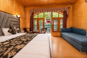 a bedroom with a large bed and a couch at Srichan Resorts in Pahalgām