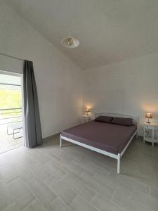 ein Schlafzimmer mit einem Bett und einem großen Fenster in der Unterkunft Чабарня in Pukhovka