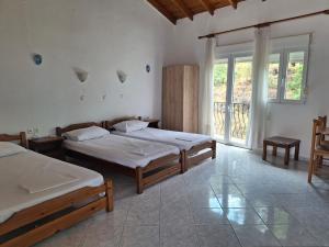 a bedroom with two beds and a large window at Studios Elena Central in Limenaria