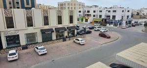 a city street with cars parked in a parking lot at Today House Suites 5 in Salalah