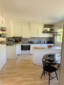 a kitchen with white cabinets and a table in it at Skid vm in Falun