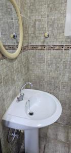 a white sink in a bathroom with a mirror at Today House Suites 5 in Salalah