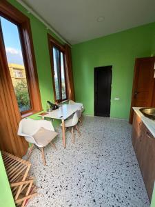 a kitchen with green walls and a table and chairs at Green Home in Kobuleti