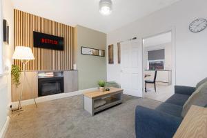 a living room with a blue couch and a fireplace at Cosy 2BR Apartment Sleeps 4 by Stay With Us in Hawthorn