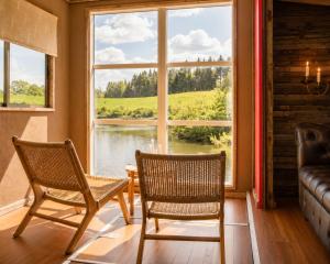two chairs in a room with a large window at Krusmølle Glamping in Aabenraa