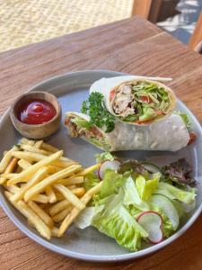 a plate of food with a sandwich and french fries at Wavedance Bali Surfhouse in Airsatang