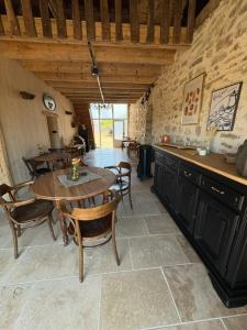 a kitchen with a table and chairs in a room at Vue sur la colline La-Roche in Bouzais