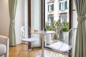 a table and chairs in a room with a window at B and G San Babila- Luxury in the heart of Milano - Design district in Milan