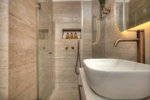 a bathroom with a white sink and a shower at Sahara Suite - סהרה סוויט in Safed