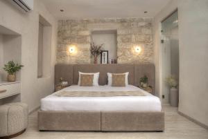a bedroom with a large bed and a stone wall at Sahara Suite - סהרה סוויט in Safed