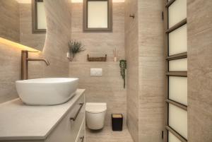 a bathroom with a white sink and a toilet at Sahara Suite - סהרה סוויט in Safed