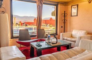 a living room with a couch and a table and a window at Hotel Bin El Ouidane in Bine el Ouidane