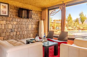 a living room with a couch and chairs and a tv at Hotel Bin El Ouidane in Bine el Ouidane