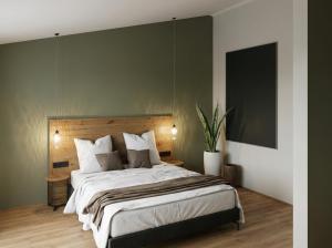 a bedroom with a large bed with a green wall at Heidehaus in Lilienthal