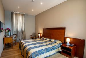 a hotel room with a bed and a table and chairs at Europalace Hotel in Verbania +4 photos
