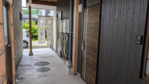 a hallway of a house with doors and a car at Takamori Guest House in Takamori