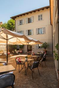 a patio with tables and chairs and a building at Albergo Castiglione Langhe in Castiglione Tinella