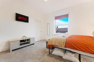 a bedroom with a bed and a desk and a window at Cosy 2BR Apartment Sleeps 4 by Stay With Us in Hawthorn