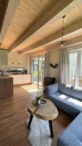 a living room with a blue couch and a table at SosnowoMi in Lubiatowo