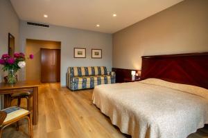 a bedroom with a bed and a chair at Europalace Hotel in Verbania