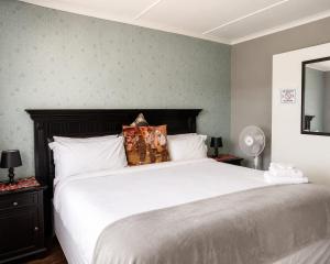 a bedroom with a large bed with white sheets at Radies Bed and Breakfast in Cofimvaba