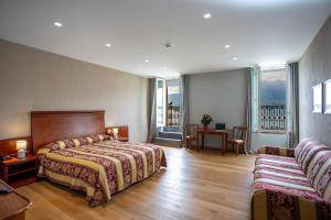 a hotel room with a bed and a table and chairs at Europalace Hotel in Verbania