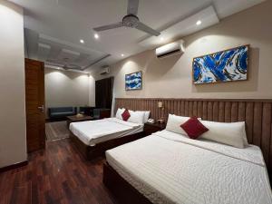 a hotel room with two beds and a living room at Shelton Hotel Gulberg in Lahore