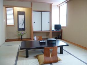 a living room with a table and two chairs at Hotel Hashimotorou in Ishioka