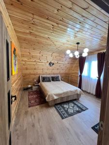 a bedroom with a bed in a wooden cabin at ValceleLakeRetreat in Merişani