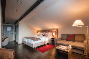 a bedroom with a bed and a couch at Hotel Bristol Verbier in Verbier