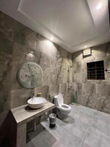 a bathroom with a sink and a toilet at Shelton Hotel Gulberg in Lahore