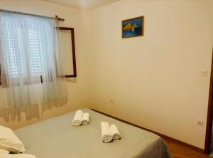 a bedroom with a bed with two pairs of slippers at Apartments Bacic in Prizba +47 photos