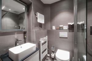 a bathroom with a sink and a toilet and a shower at Hotel Bristol Verbier in Verbier +37 photos