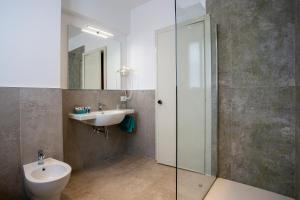 a bathroom with a sink and a toilet and a mirror at Europalace Hotel in Verbania