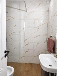 a white bathroom with a sink and a toilet at Apartpan Lekic in Bar