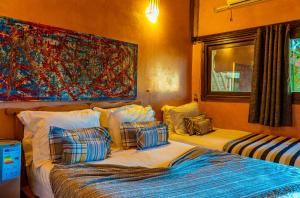 a bedroom with two beds and a painting on the wall at Hotel Bin El Ouidane in Bine el Ouidane +25 photos