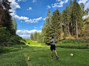 a man taking a picture of a golf course at FeWo Aquileia Scuol, Gratisparken, Terrasse, Wifi, flexible Zimmerwahl, Familien in Scuol