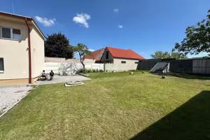a yard with a building and a grassy yard with a house at Meštiansky dom in Stupava