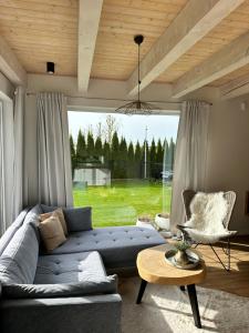 a living room with a blue couch and a table at SosnowoMi in Lubiatowo
