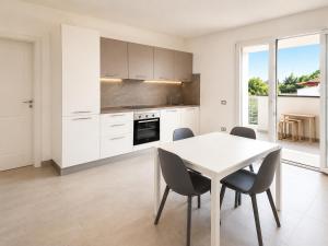 a white kitchen with a white table and chairs at Pierre Palace in Isola Sacra