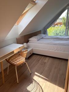 a bedroom with a bed and a desk and a window at SosnowoMi in Lubiatowo