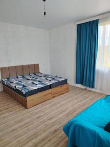 a bedroom with a bed and a blue curtain at Ghulelebi - ღულელები in Ghulelebi +3 photos