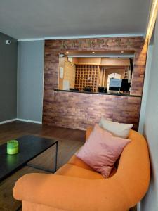 an orange couch with a pink pillow in a room at Jantar Economy in Szczecin