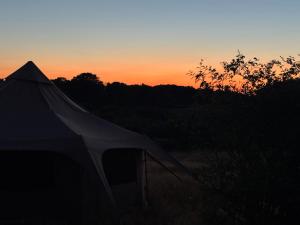 a tent with the sunset in the background at Sunset view in Hereford