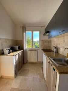a kitchen with a sink and a window at Studio au 1er étage à la campagne in Callian