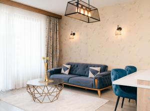a living room with a blue couch and a table at Hotel Platino Prestige in Ulcinj