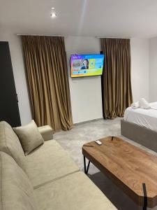 a living room with a couch and a tv at Lake Escape Villa Shirokë in Shkodër