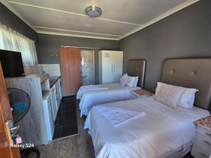 a hotel room with two beds and a television at Radies Bed and Breakfast in Cofimvaba