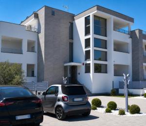 two cars parked in front of a building at Pierre Palace in Isola Sacra